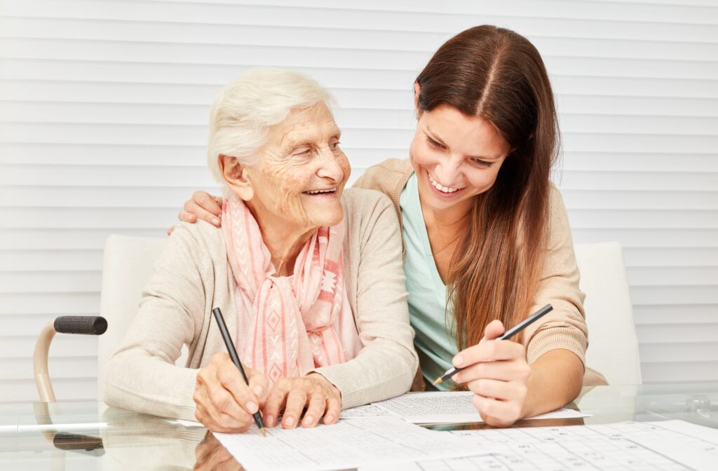 A female nurse helping a senior citizen patient with a sudoku puzzle